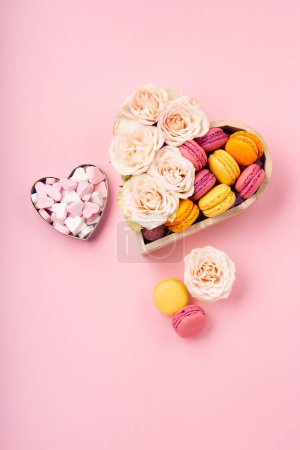 Photo for Sweet cookies macaroons in festive gift box, rose flowers and candies on pink background. Holiday presents concept for Mothers day, womans day valentines day, birthday. Top view, copy space. - Royalty Free Image