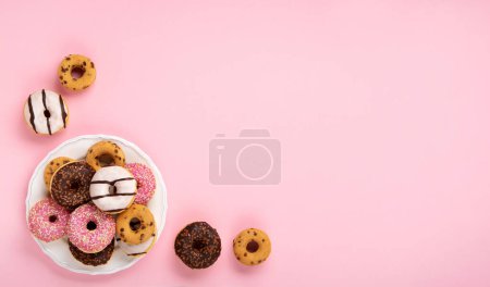 Téléchargez les photos : Donuts colorés vacances beignets avec chocolat et sucre saupoudrer sur fond rose, vue sur le dessus. Carnaval festif ou carte d'anniversaire. Bonne Journée nationale des beignets Concept. - en image libre de droit