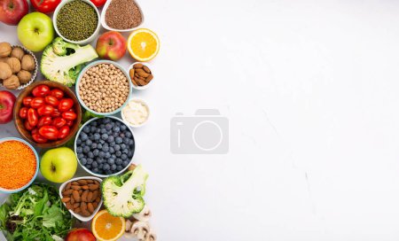 Photo for Concept of healthy lifestyle, balanced food, nutrition, clean eating food. Fresh ingredients for dietary, vegetables, fruits, nuts, meat for weight loss on white table. Healthy background, top view. - Royalty Free Image