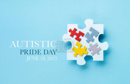 Téléchargez les photos : Concept de la Journée de la fierté autistique. Design créatif pour le 18 juin. Puzzle de couleur, symbole de sensibilisation au trouble du spectre autistique sur fond bleu. Vue du dessus, espace de copie. - en image libre de droit