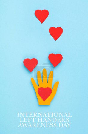 Photo for International Left Handers Day Concept, 13th august. Colorful paper left hand and red hearts on blue background, copy space, top view. - Royalty Free Image