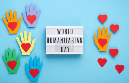 Photo for World Humanitarian Day Concept. Tolerance, kindness, cooperative, friendship, charity, humanitarian aid day concept. Colorful hands on blue background, copy space, top view. - Royalty Free Image
