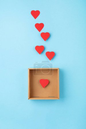 Photo for World Humanitarian Day Concept. Tolerance, kindness, cooperative, friendship, charity, humanitarian aid day concept. Red Hearts and donation box on blue background, copy space, top view. - Royalty Free Image