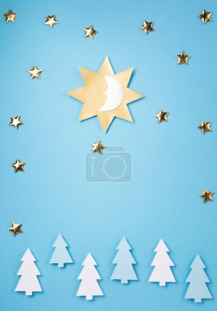 Foto de Fiesta del solsticio de invierno, 21 de diciembre. El concepto de la noche más larga del año. Sol, luna y estrellas doradas simbolizan sobre fondo de papel azul. Plano, vista superior, espacio para copiar - Imagen libre de derechos