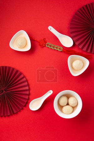 Téléchargez les photos : Boulettes de riz sucrées boules Tang Yuan pour le festival chinois Dongzhi et la nourriture du festival du nouvel an lunaire. Concept de journée Solstice d'hiver sur fond rouge. Vue du dessus, espace de copie. - en image libre de droit