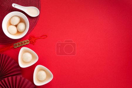 Téléchargez les photos : Boulettes de riz sucrées boules Tang Yuan pour le festival chinois Dongzhi et la nourriture du festival du nouvel an lunaire. Concept de journée Solstice d'hiver sur fond rouge. Vue du dessus, espace de copie. - en image libre de droit