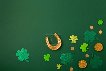 Photo for St Patricks day card with traditional symbols for irish party. Golden horseshoe, gold coins, clover leaves, green shamrocks on green background. Top view. St. Patrick's Day celebration concept. - Royalty Free Image