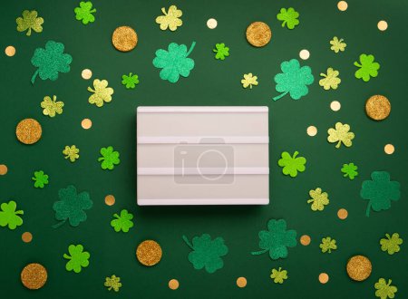 Téléchargez les photos : Carte de jour St Patricks avec symboles traditionnels pour fête irlandaise. Fer à cheval doré, pièces d'or, feuilles de trèfle, trèfles verts sur fond vert. Vue du dessus, espace de copie. Concept de célébration de la Saint-Patrick. - en image libre de droit