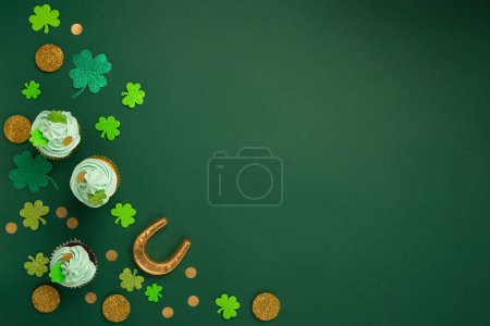 Photo for St. Patrick's Day vanilla and chocolate cupcakes with green frosting and  shiny clover decorations on green paper background. Irish holiday dessert concept. Top view, copy space. - Royalty Free Image