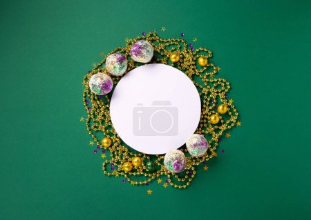 Téléchargez les photos : Cupcakes festifs avec perles Mardi Gras et décor violet, or, vert sur fond vert. Invitation de fête, concept de carte de voeux. - en image libre de droit