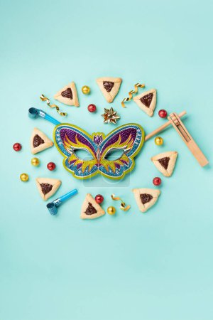 Photo for Tradition homemade hamantaschen cookies, Carnival mask, noisemaker, sweet candies and festive party decor on blue mint background. Purim celebration jewish holiday concept. - Royalty Free Image