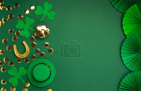 Téléchargez les photos : Chapeau de lutin de la Saint-Patrick, pièces d'or et trèfles sur fond vert. Concept de vacances traditionnel irlandais. Vue du dessus, espace de copie. - en image libre de droit