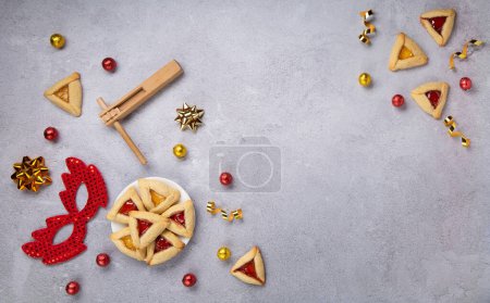 Photo for Homemade Purim hamantaschen cookies, Triangular pastry and festive Carnival party decor on gray stone background, Top view. Purim celebration jewish holiday concept, copy spase. - Royalty Free Image