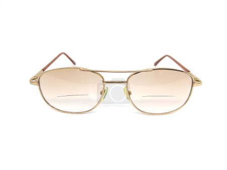 Gafas graduadas con lente bifocal aislada sobre fondo blanco. Primer plano de gafas de montura dorada.