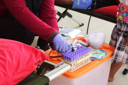 Téléchargez les photos : Médecin prélève un échantillon de sang du patient pour tester la teneur en sang à l'hôpital dans le centre de Java, Indonésie, le 22 août 2022. donneurs de sang à donner au patient. - en image libre de droit