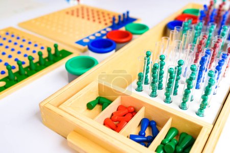 Detail von Stiften und Bohnen auf einem Montessori-Brett zur Durchführung mathematischer Teilungen.