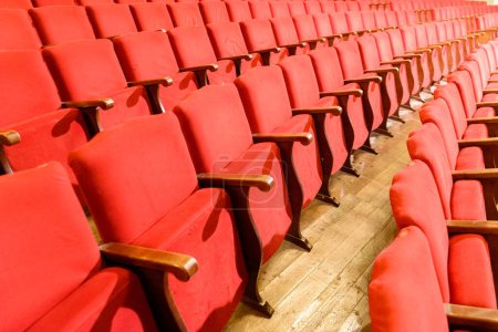 Foto de Fila de asientos rojos en un teatro con suelo de madera viejo. - Imagen libre de derechos