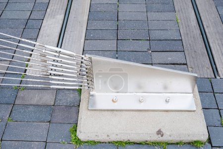 Foto de Las estancias de acero unidas a un soporte conducido al suelo sostienen los cables de acero de un puente. - Imagen libre de derechos