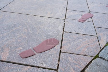 Fußabdrücke auf dem Boden, gemalt, um eine Touristenroute in einer Stadt zu markieren.