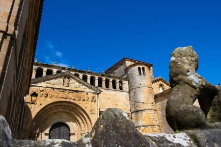 A statue of a teddy bear stands in front of a historic building in the medieval town of Santillana del Mar, Cantabria. The bear is depicted in a playful pose, adding a touch of whimsy to the architectural surroundings.