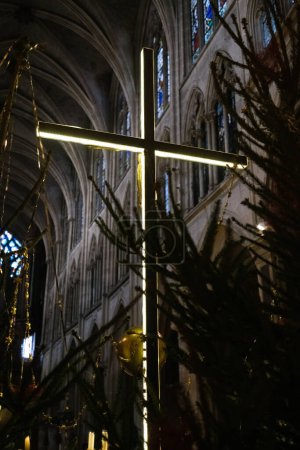 Foto de Una cruz moderna con ledes ilumina el interior de una iglesia europea oscura. - Imagen libre de derechos
