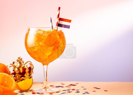 Sommer Coctail Aperol Spritz im Glas mit holländischer Veranstaltung Kings Day im Hintergrund. Nationalfeiertag Koningsdag am 27. April in den Niederlanden. Holland Kulturkonzept mit Kopierraum