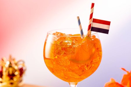 Großaufnahme von Coctail Aperol Spritz im Glas mit dem holländischen Königstag Koningsdag im Hintergrund. Nationalfeiertag in den Niederlanden. 27. April