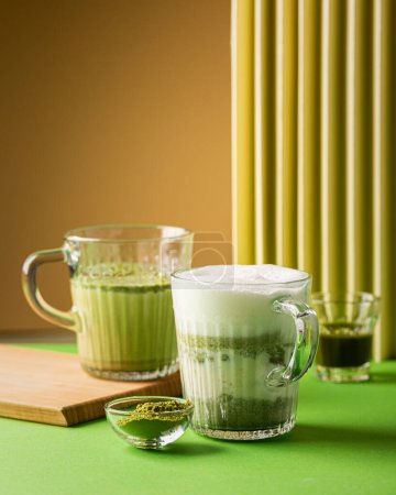 Photo for Matcha green tea latte in a glass on green yellow background. Healthy vegan drink with plant based milk. Copy space - Royalty Free Image
