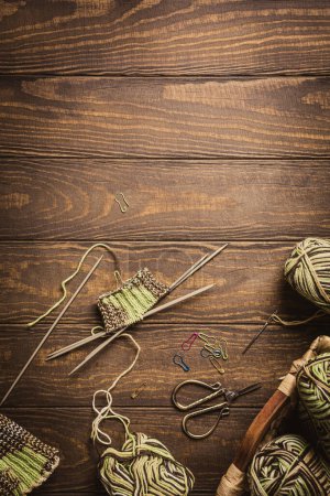 Photo for Handmade knitting project of knitting green socks in progress. Cozy homely atmosphere with wooden table. Hobby flat lay with copy space - Royalty Free Image