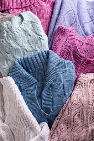 Photo for Overhead view of folded handmade assorted sweater clothing. Homemade colorful knitted clothes background - Royalty Free Image