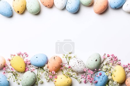 Photo for Easter quail eggs and springtime flowers over white background. Spring holidays concept with copy space. Top view - Royalty Free Image