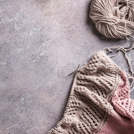 Photo for Knitting flat lay with pink and grey wool yarn and knit accessories over gray, top view. Shot from above with copy space. Retro style toned - Royalty Free Image