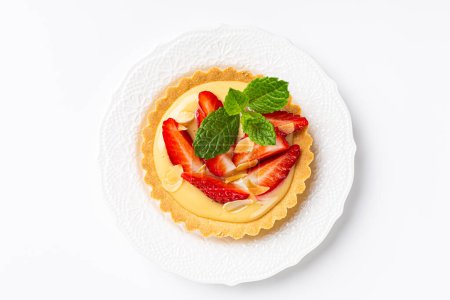 Photo for Overhead shot of strawberry mini cake tartlet with vanilla custard and mint leaves over white background. Concept of homemade sweet pastries. Copy space, top view - Royalty Free Image