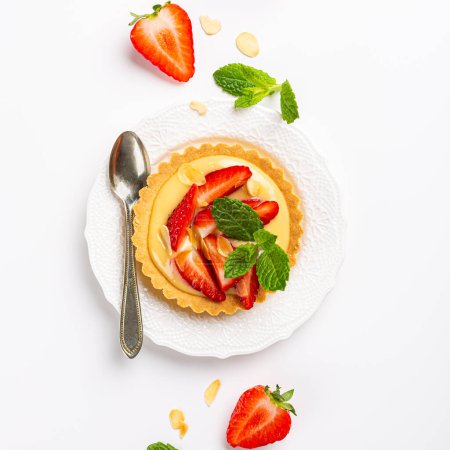 Photo for Overhead shot of strawberry mini cake tartlet with vanilla custard and mint leaves sprinkled with almond flakes over white background. Concept of homemade sweet pastries. Copy space, top view - Royalty Free Image