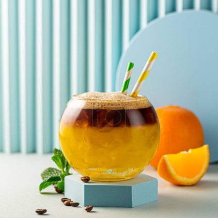 Photo for Summer trendy refreshing drink bumble coffee with espresso, orange juice, crashed ice and syrup in layers in transparent glass with ice. Copy space - Royalty Free Image
