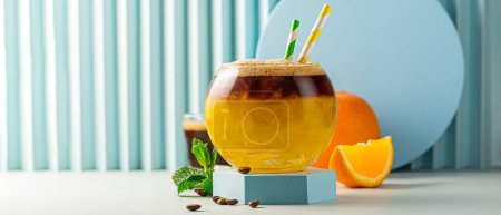 Photo for Banner with bumble coffee on blue background. Espresso, orange juice, crashed ice and syrup in layers in transparent glass with ice. Summer trendy refreshing coffee drink. Copy space - Royalty Free Image