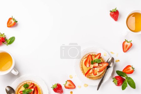 Photo for Summer composirion with strawberry mini cake tartlet with vanilla custard, sprinkled with almond flakes and mint over white. Concept of high tea healthy sweet pastries with copy space and above view - Royalty Free Image