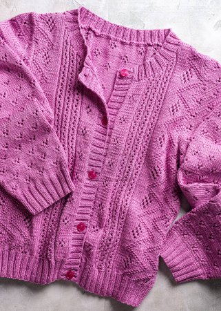 Photo for Fuchsia color handmade buttoned long sleeve female cotton cardigan with knitted lace pattern. Top view. Modern jersey apparel for ladys and girls - Royalty Free Image