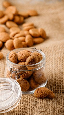 Photo for Dutch holiday Sinterklaas traditional cookies kruidnoten in glass jar on sackcloth. Pepernoten, traditional sweets, strooigoed. Concept Saint Nicholas day. Story template and phone background format - Royalty Free Image