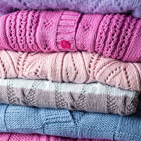 Photo for Close up view of stack folded handmade sweater clothing. Homemade colorful knitted zelfmade clothes background - Royalty Free Image