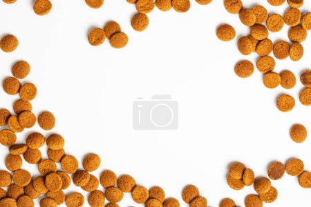 Photo for Festive background fot Dutch holiday Saint Nicolas Sinterklaas with copy space. Kruidnoten cookies over white. Concept for children party day five december in the Netherlands. Top view, overhead. - Royalty Free Image