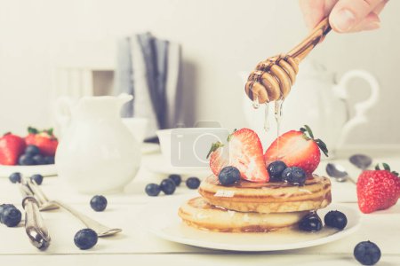 Photo for Healthy breakfast concept. Homemade pancakes with strawberries, blueberries and honey. Retro style toned. - Royalty Free Image