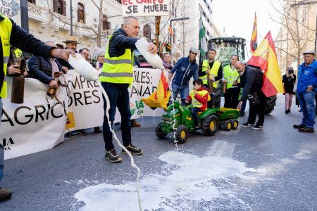 Téléchargez les photos : Grenade, Andalousie, Espagne. 20 février 2024 : Manifestation des agriculteurs protestant contre la crise des prix déloyaux des produits agricoles, dans les rues de Grenade avec des banderoles et des tracteurs - en image libre de droit