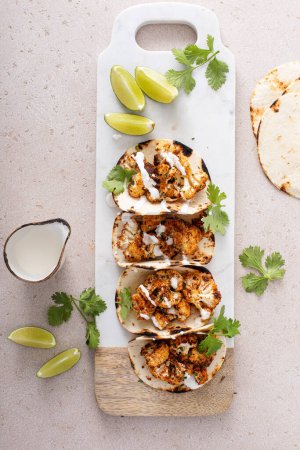 Spicy roasted cauliflower tacos with cilantro and mexican crema
