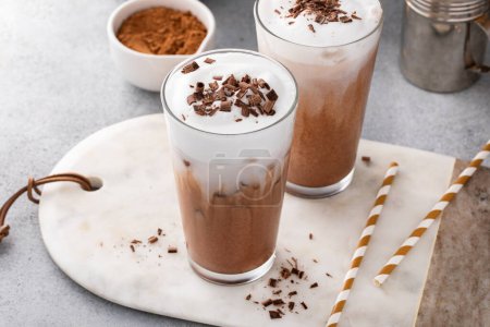 Photo for Cold hot chocolate in tall glasses with milk foam topped with chocolate curls - Royalty Free Image