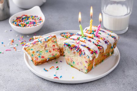 Photo for Birthday cake pound cake with sprinkles, funfetti cake on a plate with candles - Royalty Free Image