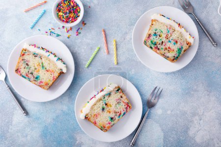 Photo for Birthday cake or funfetti pound cake with sprinkles and frosting sliced ready to eat - Royalty Free Image