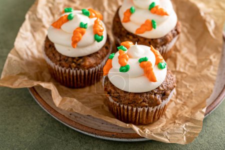 Carrot cupcakes with cream cheese frosting decorated with tiny frosting carrots, Easter dessert idea