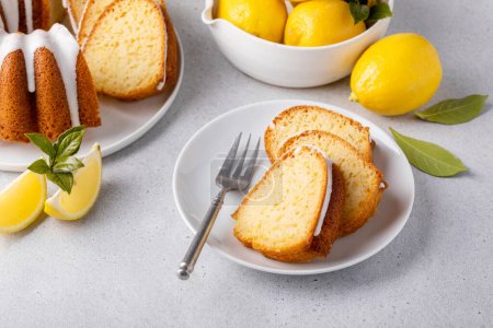 Photo for Lemon bundt cake drizzled with powdered sugar glaze topped with lemon zest sliced - Royalty Free Image