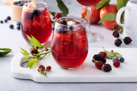 Sangria de vid roja de bayas y manzanas, refrescante idea de bebida de verano con mora y arándanos